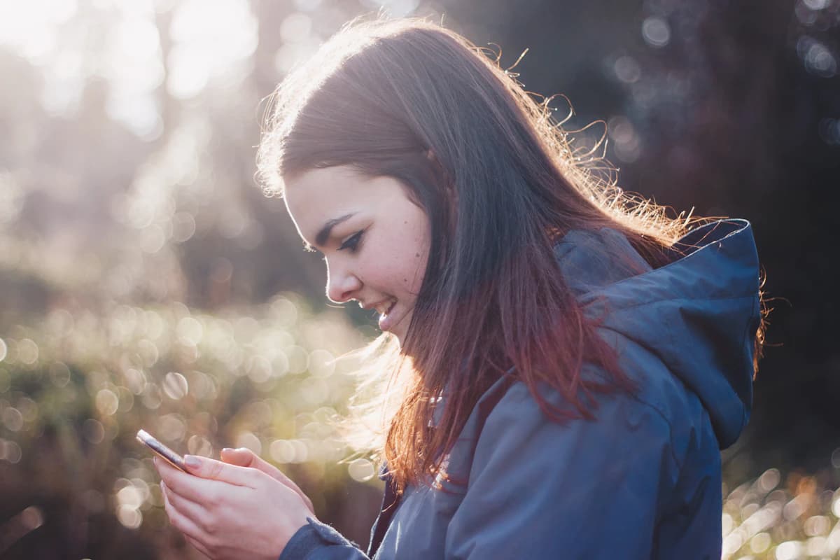 Someone smiling while reading a message on their phone